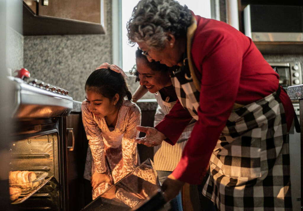 grandmother and children looking in the stove