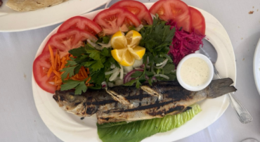 plat with whole cooked fish and tomato